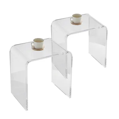 Two clear acrylic U-shaped tables are shown side-by-side against a white background. Each table has a small white cup and saucer on top.