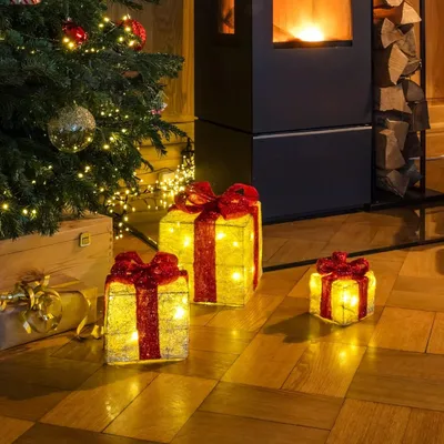 Christmas tree and fireplace with decorative gift boxes.