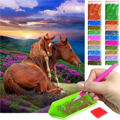 A diamond painting kit with a picture of horses on a mountain meadow and the accessories for creating it.