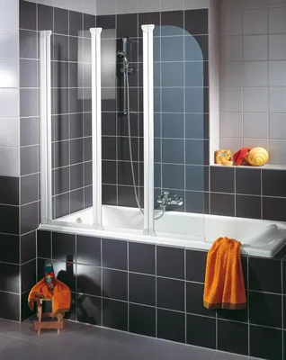 A bathroom with a bathtub and a shower screen.