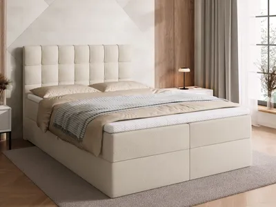 A beige upholstered boxspring bed with a tufted headboard is shown in a bedroom setting.