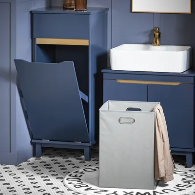 A bathroom scene with a blue cabinet, sink, and laundry basket.