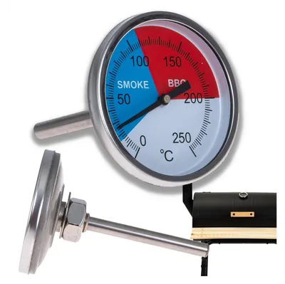 A thermometer for a BBQ or pizza cooker, shown with a portion of a black BBQ cooker in the background.