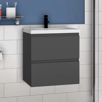 A bathroom vanity with a sink and faucet against a tiled wall.