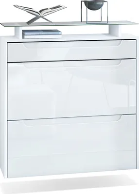 A white shoe cabinet with two drawers and a glass shelf on top, decorated with a book and a bowl.