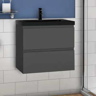 A modern bathroom vanity with a dark gray cabinet and a black countertop and sink, mounted on a tiled wall.