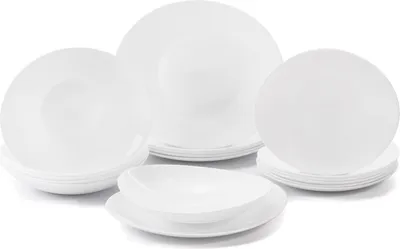 A collection of white ceramic plates and bowls are arranged on a white background.