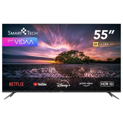 A Smart-Tech 55-inch 4K Ultra HD TV displaying a colorful sunset scene with various streaming service logos at the bottom.