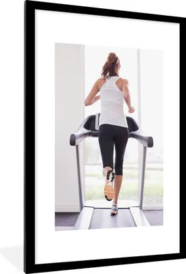 Produktbild von MuchoWow® Gerahmtes Poster Eine Frau trainiert auf einem Laufband 60x90 cm - Poster mit Schwarzem Bilderrahmen Wandposter Rahmen Foto Bilder - Dekoration - Wandposter Wohnzimmer - Hochwertig