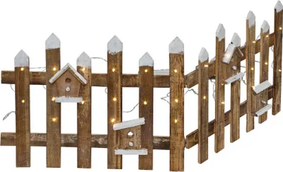 A wooden fence decorated with small birdhouses and illuminated by LED lights.