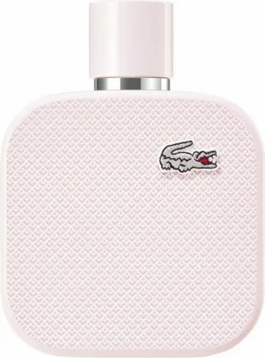 A close-up studio shot of a pink Lacoste perfume bottle.