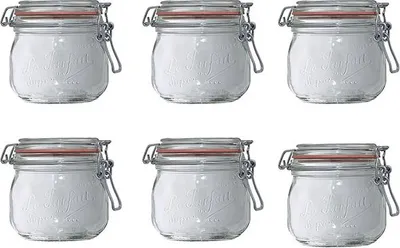 Six glass jars with red lids and silver clasps, filled with a white substance, arranged in two rows of three.