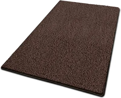 A dark brown shaggy rug is shown from a slightly elevated angle on a white background.