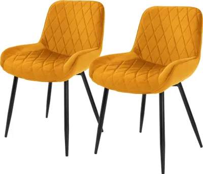 Two mustard yellow velvet dining chairs with black metal legs are shown against a white background.