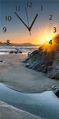 Produktbild von Wallario Design Wanduhr Sonnenuntergang hinter einem Felsen am Strand aus Echtglas, Größe 30 x 60 cm