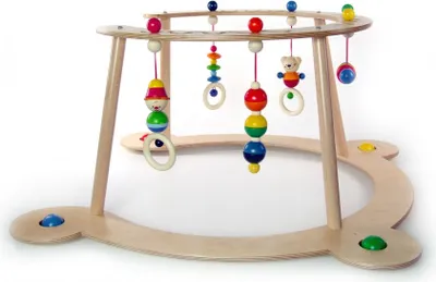 A wooden baby walker with hanging toys.