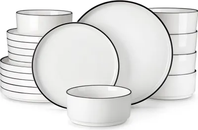 A set of white ceramic plates and bowls with black rims, neatly arranged.