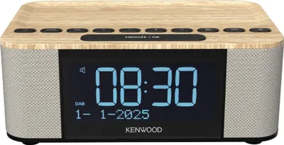 A digital alarm clock radio with a wood-effect top and fabric speaker grilles.
