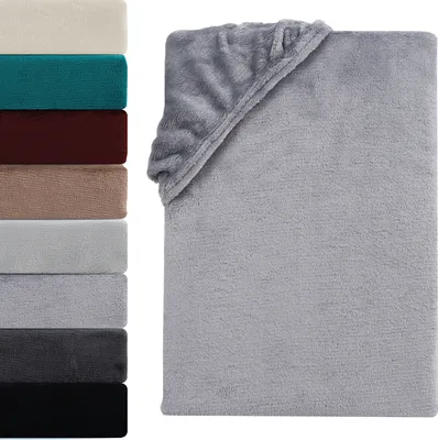 A stack of folded blankets in various colors is shown on the left, with a folded gray blanket prominently displayed on the right.