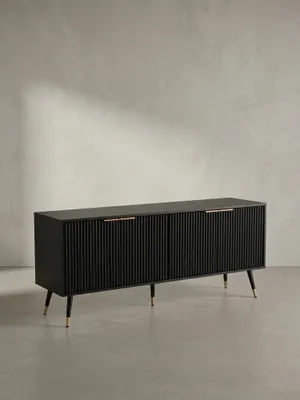 Frontansicht des schwarzen TV-Lowboards 150x60 cm mit vier geriffelten Türen und dezenten Messinggriffen, freigestellt vor neutralem Hintergrund._#sku_SAFWL6.886#