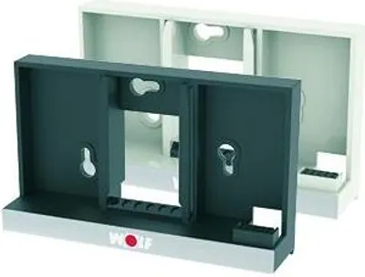 Two electrical enclosure housings, one dark gray and one white, are shown. The dark gray housing is in the foreground and appears to be a mounting bracket.