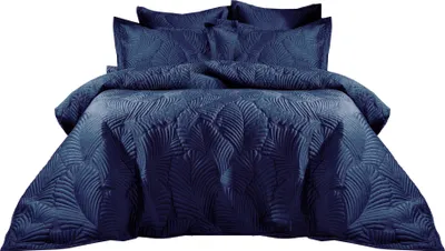 A navy blue quilted duvet set with a leaf pattern is displayed on a bed.