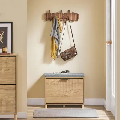 An entryway with a shoe bench, coat rack, and a shoe cabinet.