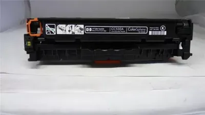 A black toner cartridge is shown on a white surface.