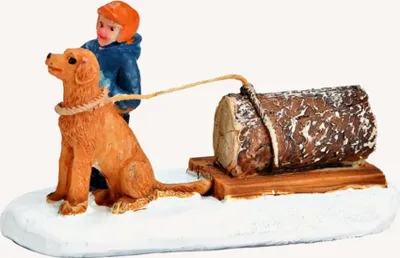 Ein Kind, das einen Holzstamm auf einem Schlitten mit Hilfe eines goldenen Retrievers zieht.