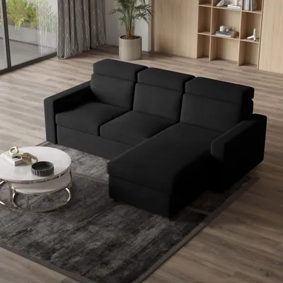 A modern living room with a black sectional sofa, a coffee table, and a rug.