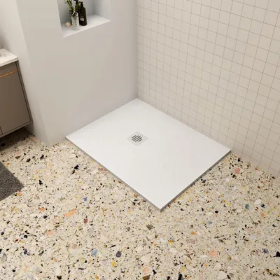 A modern bathroom corner with a white shower tray on a terrazzo floor and tiled walls.