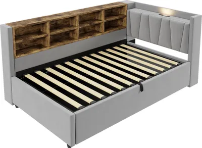 A light gray upholstered sofa bed with a wooden shelf headboard is shown from a slightly elevated side angle against a white background.