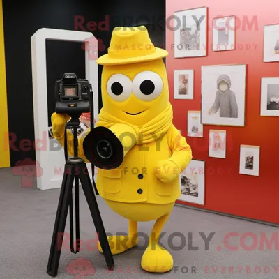 Immagine prodotto di Personaggio in costume mascotte REDBROKOLY della fotocamera gialla vestito con un blazer e scialli
