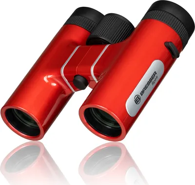 A pair of red Bresser Sirius binoculars is shown on a white background with a reflection.