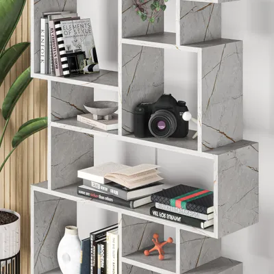 A modern, modular bookshelf unit with a marble effect finish, displaying various decorative items and books.
