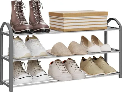A three-tier shoe rack filled with various shoes and a box on the top shelf.