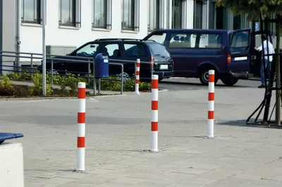 Produktbild von Schake Absperrpfosten umlegbar aus Stahlrohr verzinkt Ø76x2,5mm weiß mit rot reflektierenden Leuchtstreifen, Dreikantverschluss, Dübelbefestigung und Stahlkappe 900mm Überflur