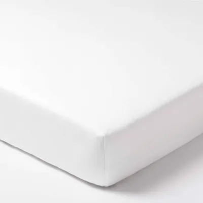 A close-up view of a white fitted sheet.