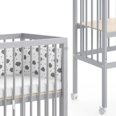 Two baby cribs, one in the foreground and another in the background, against a white background.