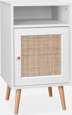 A white bedside table with a rattan door and wooden legs is shown against a white background.