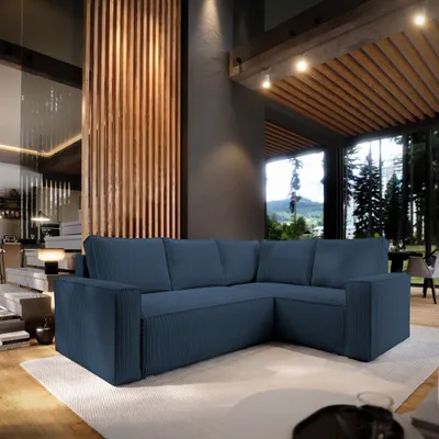 A modern living room with a large sectional sofa in blue, featuring a wooden slatted wall and large windows overlooking a forest.
