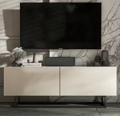 A modern TV stand with a television and decorative items in a stylish living room setting.