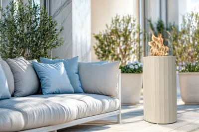 An outdoor patio with a sofa and a portable fireplace.