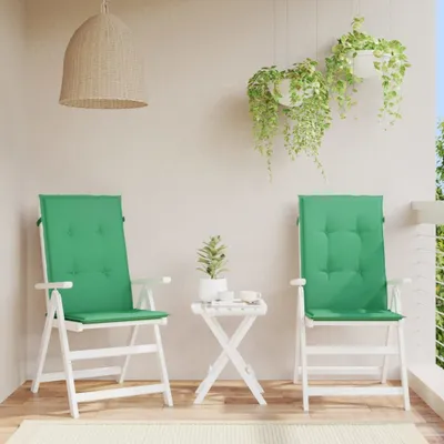 Two green chair cushions are placed on white folding chairs on a balcony.