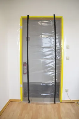 A plastic dust protection door with zippers is installed over a doorway.