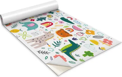 A roll of self-adhesive decorative film with a colorful animal pattern, partially unrolled.