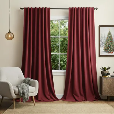 A living room scene with burgundy curtains, a chair, and a cabinet.