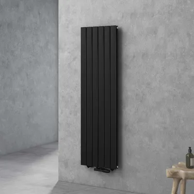 A black vertical radiator mounted on a gray concrete wall in a modern bathroom setting.