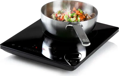 A single-burner induction cooktop with a frying pan containing food on top.
