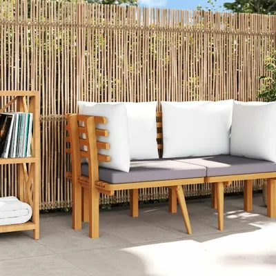 A wooden sofa with cushions is placed in front of a bamboo fence, with a small bookshelf to the left.